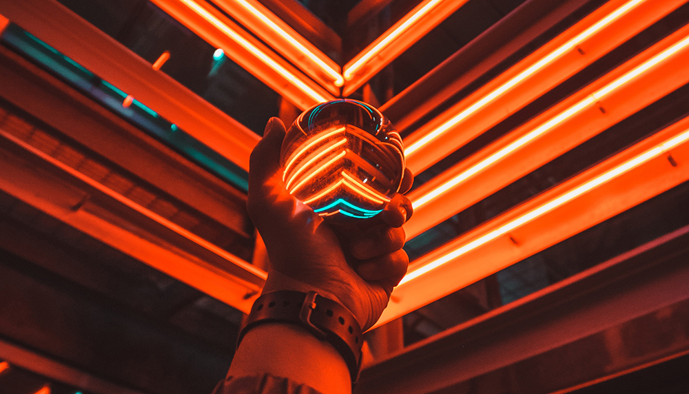 Photo of a glass ball refracting neon lights behind it